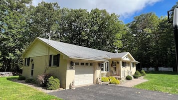 A single-story house with a garage, a front porch, and a driveway.