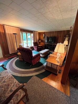 Una sala de estar acogedora con chimenea, televisión y comedor.