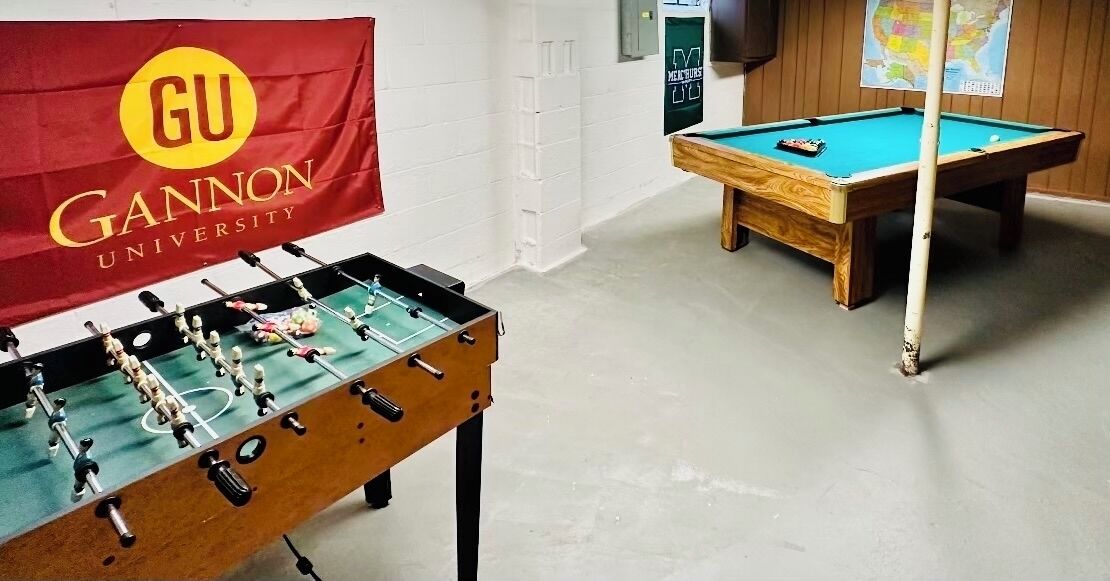 A room with a foosball table and a pool table.