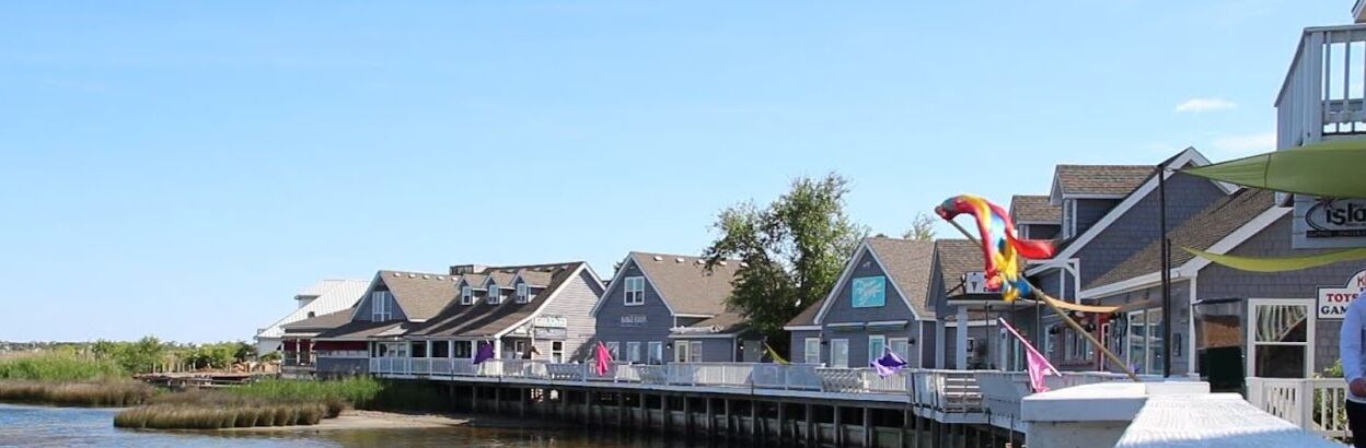 Une propriété située au bord de l’eau, dotée d’une jetée, de maisons et d’un panneau indiquant « Île Bleue ».