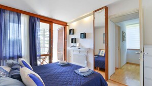 Ein Schlafzimmer mit einem großen Bett, einem Nachttisch, einem Spiegel und einem Kleiderschrank.