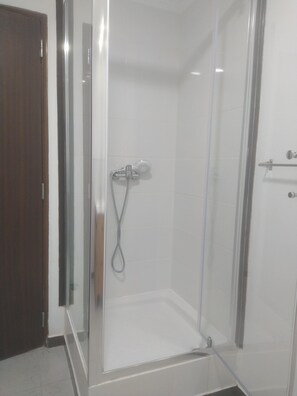 Een douche, handdoeken, zeep, shampoo