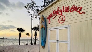 A beachside building with a surfboard mounted on the wall and a sign that reads "you only live once." - Lakefront Sandestin Home w/ Golf Cart &Arcade Room (Mir)