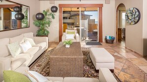 A spacious living area with a sofa, a coffee table, and a view of the balcony. - Casa de Bella Paz, Peaceful 3 Bedroom Oceanview Penthouse at Bella Sirena (Puerto Peñasco)