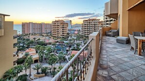 A resort with multiple buildings, a pool area, and a view of the sea at sunset. - Casa de Bella Paz, Peaceful 3 Bedroom Oceanview Penthouse at Bella Sirena (Puerto Peñasco)