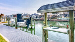 A dock with a boat, wooden pier, and houses in the background. - It`s clock out time! (Rockport)