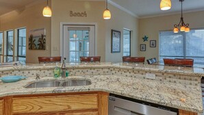 A kitchen with a large island, double sinks, and pendant lighting. - It`s clock out time! (Rockport)