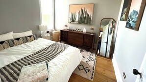 A bedroom with a bed, bedside table, dresser, and a large mirror. - Irving Park/Avondale Updated Vintage Top Unit in 2-Flat (Chicago)