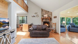 A spacious living room with a fireplace, wooden floors, a high ceiling, and a cozy seating area. - 20% OFF NEW Dock, Pavilion, Hot Tub, Kayaks, Lakefront- Blue Heron Landing (Dandridge)