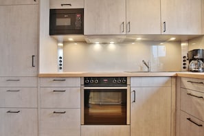 A modern kitchen with a built-in oven, microwave, and coffee maker.