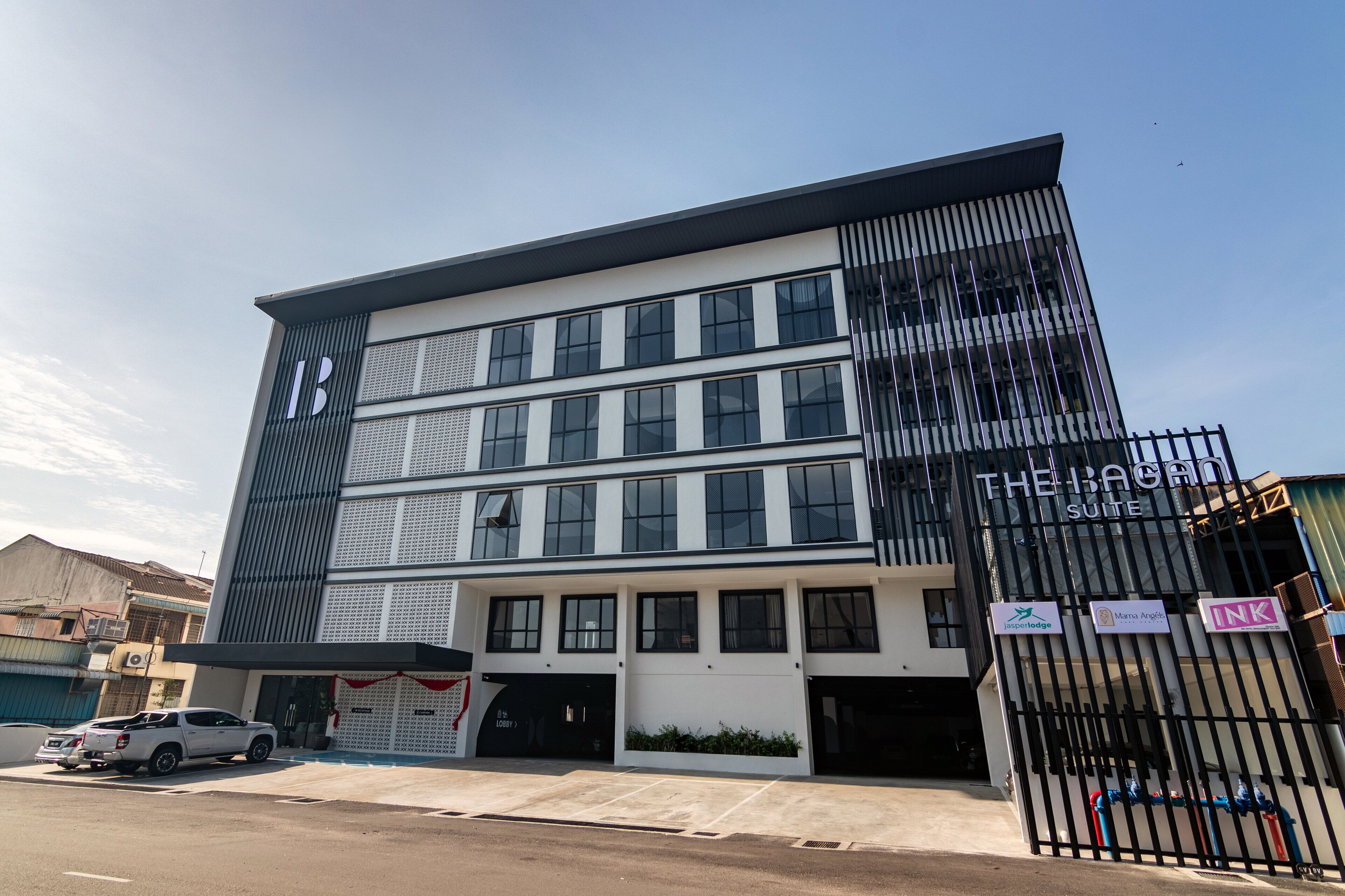 Un bâtiment moderne avec une enseigne indiquant « The Bagan Suite ».