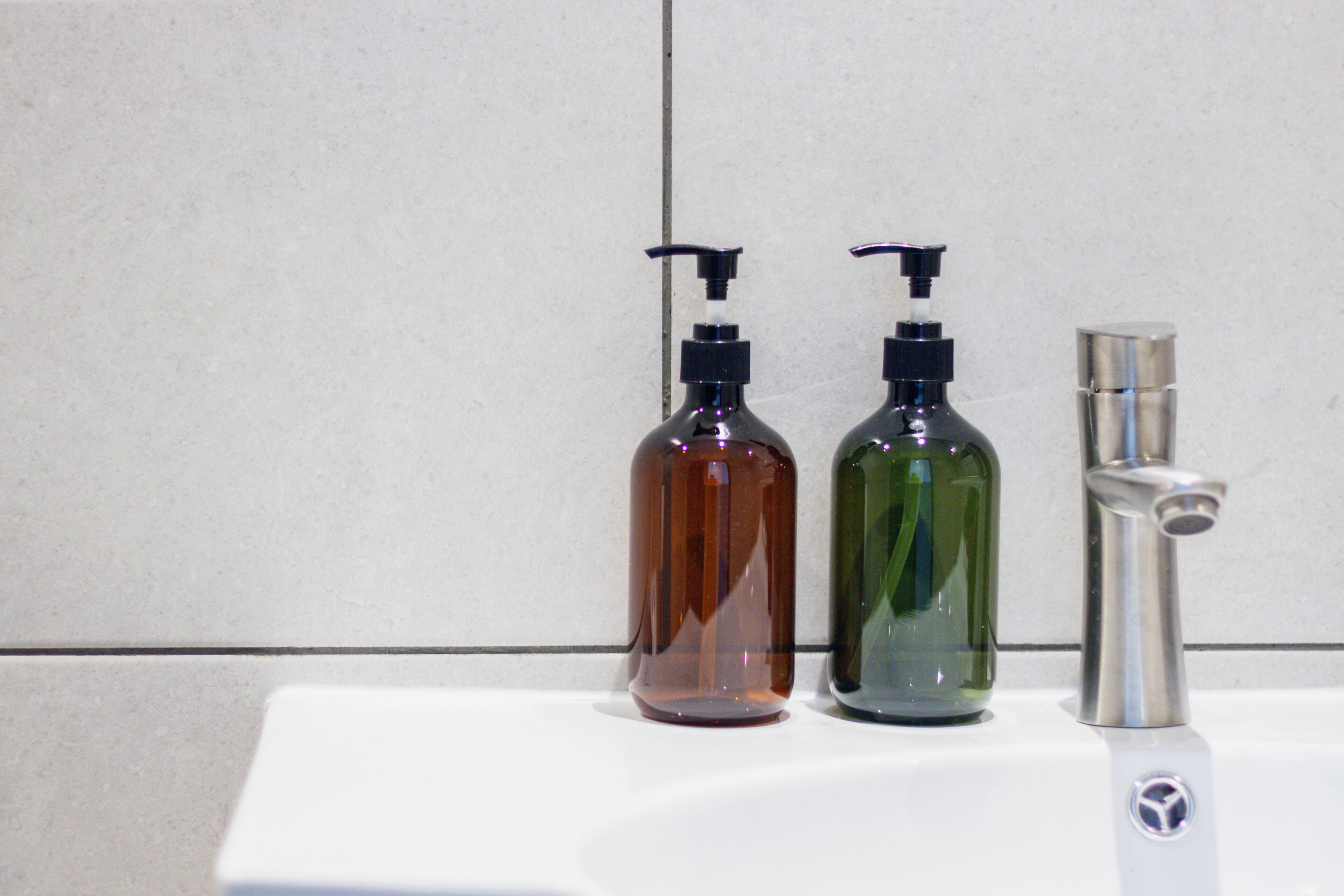 Ein Waschbecken mit zwei Seifenspendern und einem Wasserhahn.