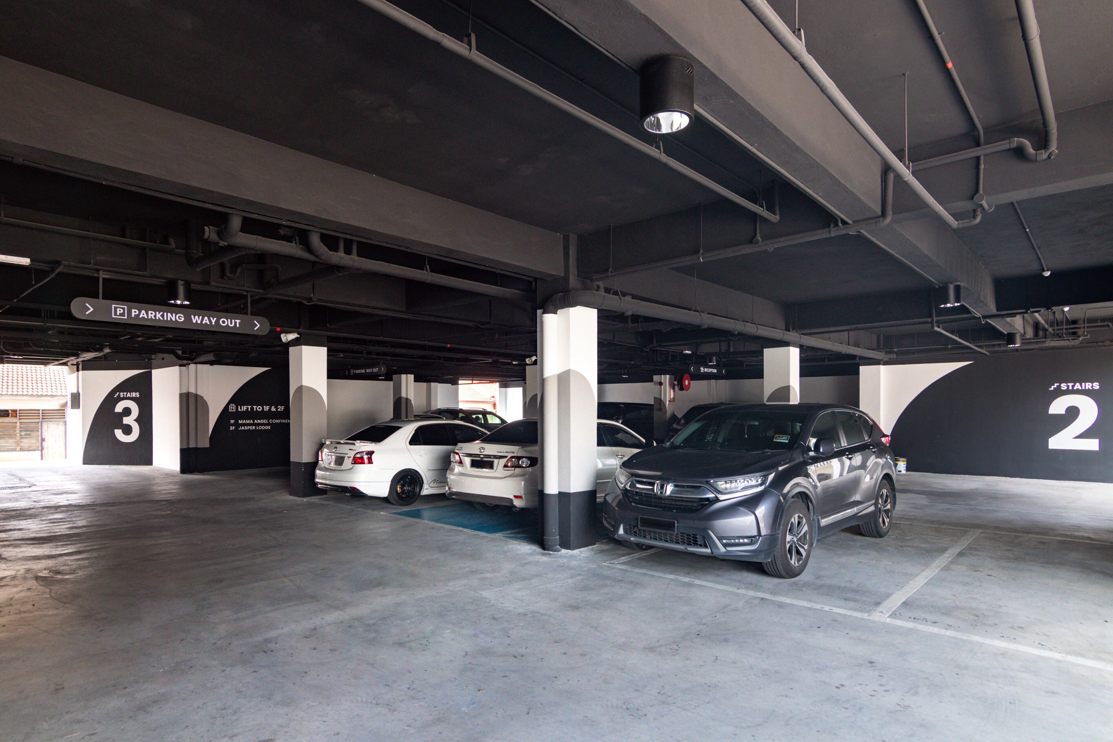 A multi-level underground parking garage with clearly marked parking bays and directional signs.