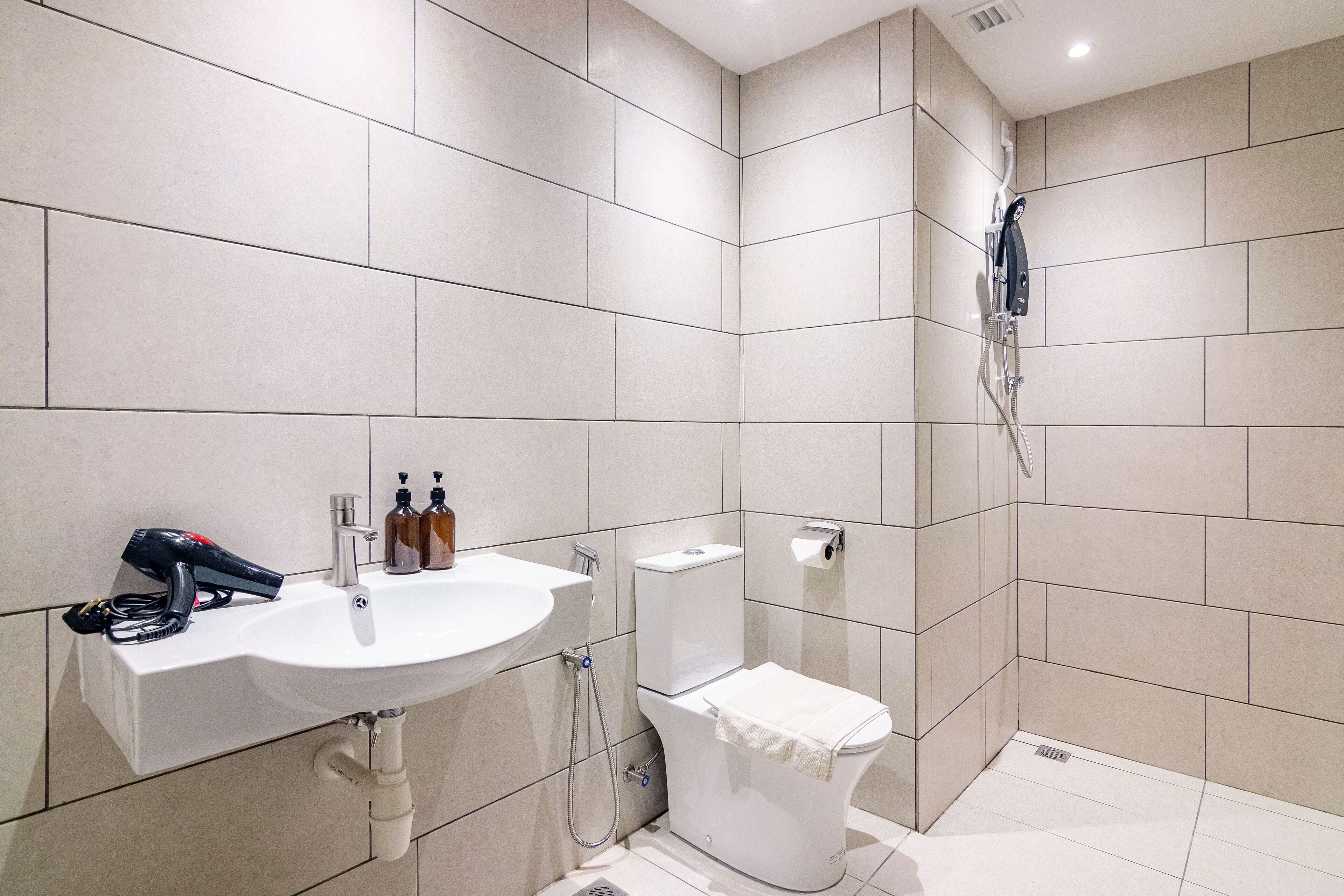 Un baño moderno con lavamanos, inodoro y ducha.