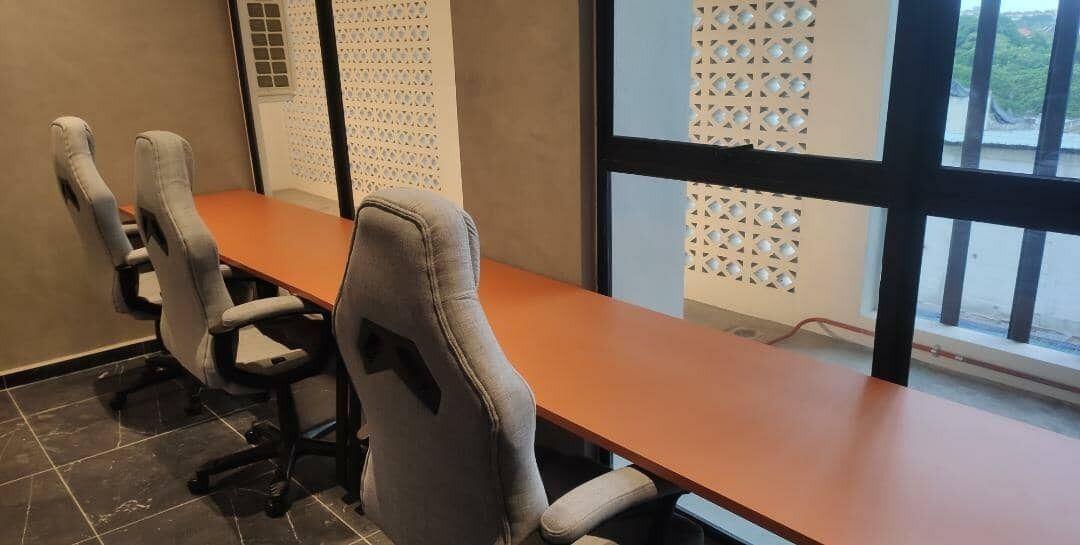 Une salle de conférence avec une longue table et quatre chaises.