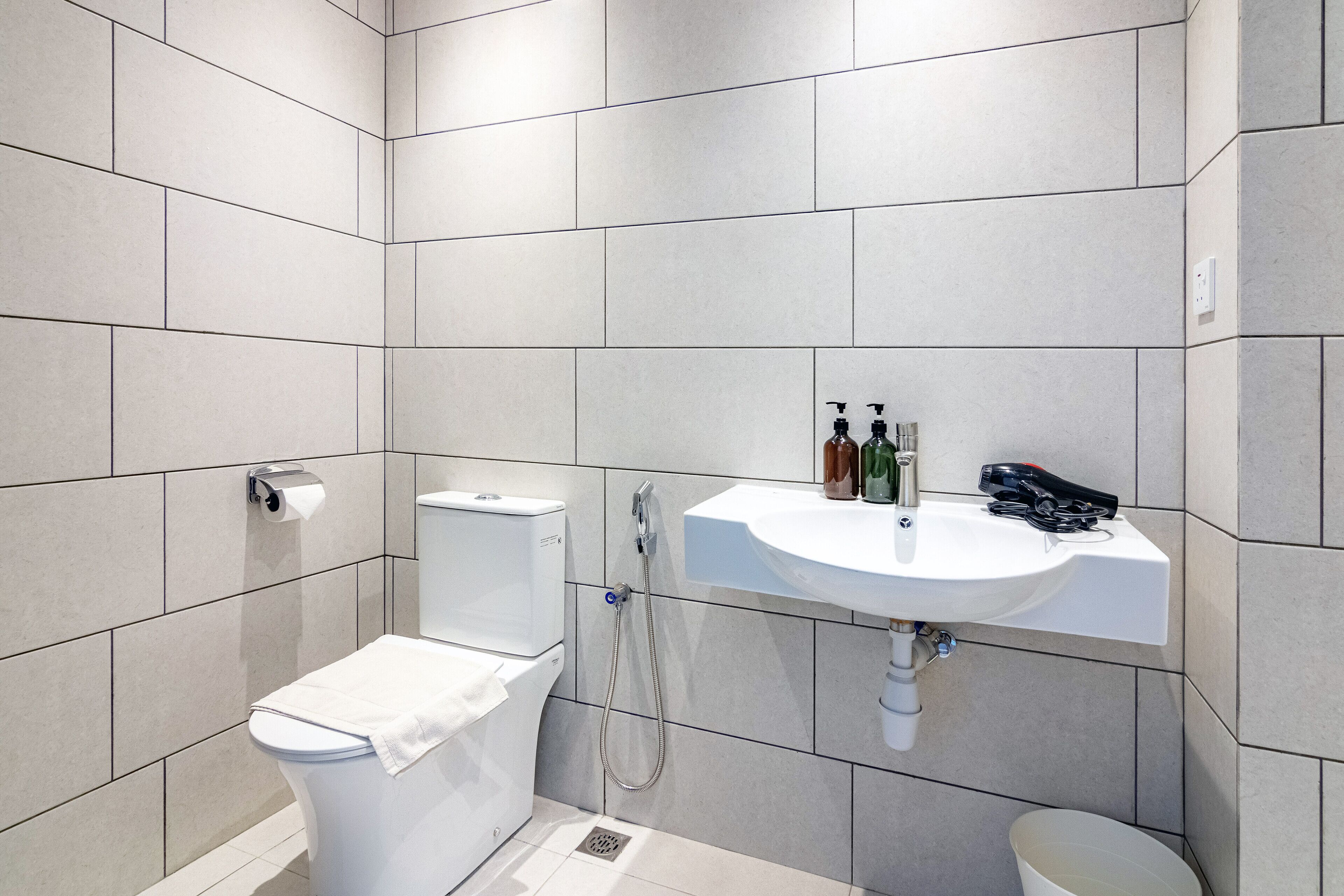 A modern bathroom with a toilet, bidet, and sink.