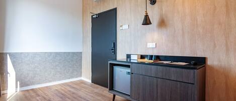 A modern kitchen with a dark wooden cabinet, a built-in dishwasher, and a wall-mounted light fixture.