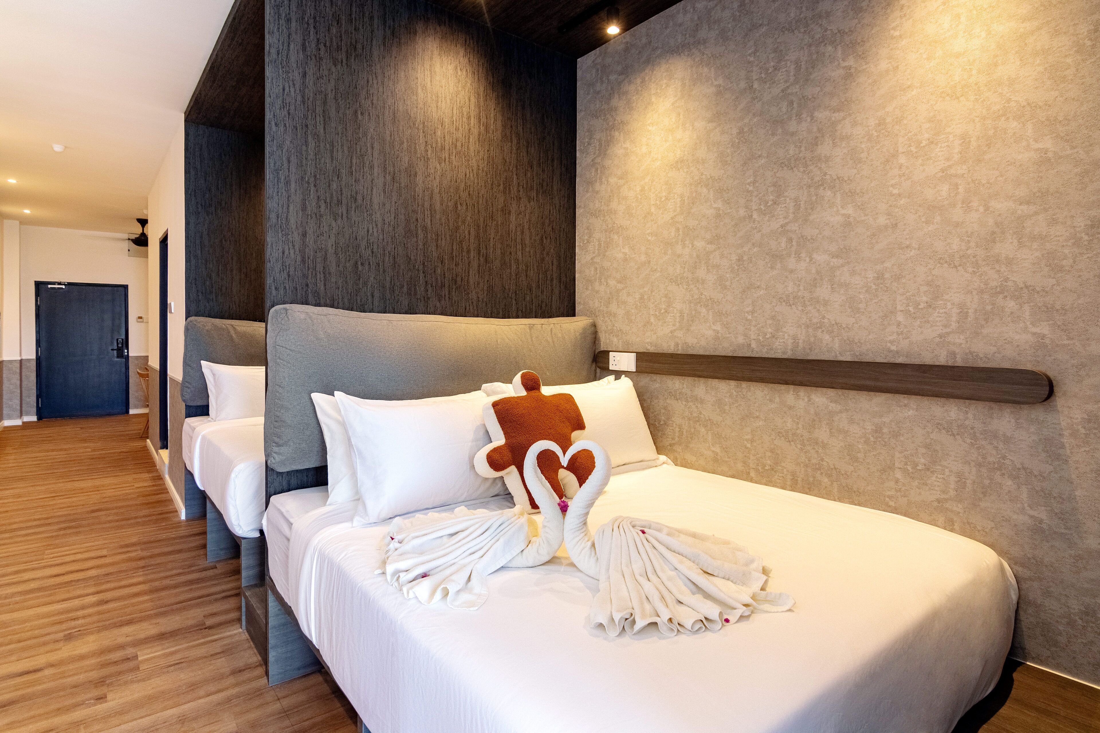 Habitación de hotel con una cama grande, cabecera de madera y una lámpara fijada a la pared.