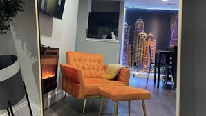 Ein modernes Wohnzimmer mit Kamin, einer Couch und Blick auf die Stadt.