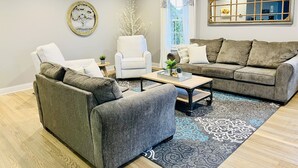 A modern living room with a grey sofa, a white armchair, and a coffee table.
