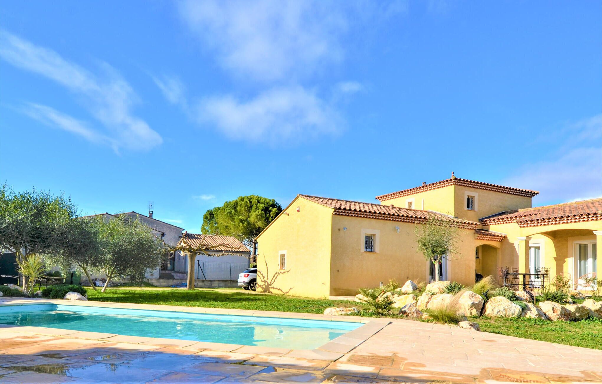Ein Wohnhaus mit Swimmingpool, Terrassenbereich und gepflegtem Garten.