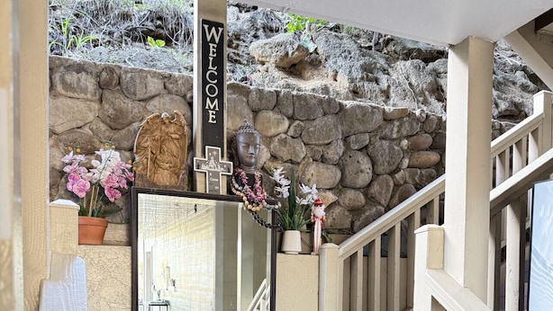 A staircase leading to a stone wall with a 'WELCOME' sign, a framed mirror, and potted plants. - Unit 25 Waena Inn - Maui Private Suite (Wailuku)
