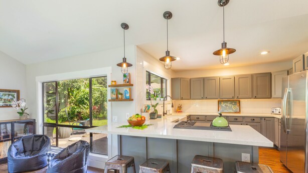 A modern kitchen with a large island, bar stools, and pendant lighting. - Princeville Private 3 bed 2 bath w/AC (Princeville)