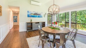 A dining area with a round table, chairs, and a hanging light fixture. - Princeville Private 3 bed 2 bath w/AC (Princeville)