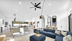 A modern living room with a sectional sofa, a coffee table, and a ceiling fan. - Ultra modern contemporary Luxe (Palm Springs)