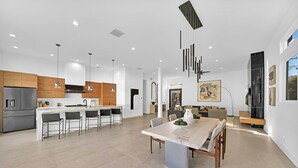 A modern kitchen with a central island, bar stools, and pendant lighting. - Ultra modern contemporary Luxe (Palm Springs)