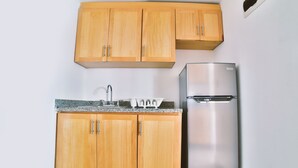 Una cocina con armarios de madera, un refrigerador de acero inoxidable y una encimera de granito.