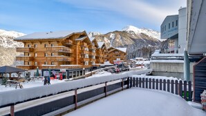 A wooden multi-story building with balconies, surrounded by snow-covered mountains. - Appartement Savoleyres 10 - La Tzoumaz, 4 Vallees (La Tzoumaz)