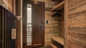 Interior em madeira com porta que dá para uma vista, um radiador e um cabideiro suspenso.