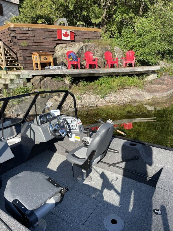 Un bateau équipé d’un volant, d’un panneau de commande et d’un espace pour s’asseoir.