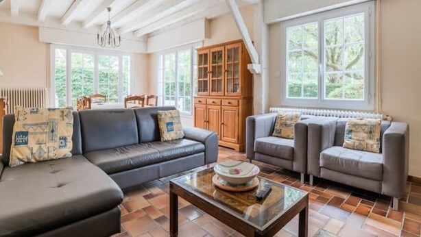 Un salon spacieux avec une grande fenêtre, une cheminée et un meuble en bois.