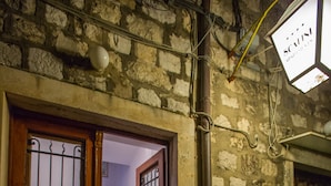 A stone building with a wooden door and potted plants. - Casa Arancia (Dubrovnik)