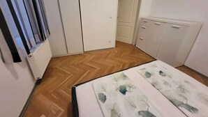 Une chambre à coucher avec un lit, une armoire et un radiateur.