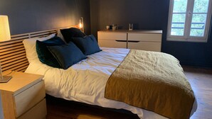 A bedroom with a bed, bedside tables, a dresser, and a window. - Downtown Toulouse house with pool (Toulouse)