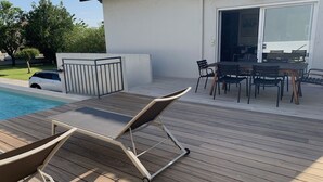 A wooden deck with lounge chairs and a dining table. - Downtown Toulouse house with pool (Toulouse)