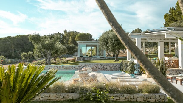 Une villa moderne dotée d’une piscine, d’un espace salon extérieur et d’une pergola.