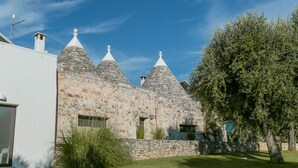 Un bâtiment en pierre doté de trois toits coniques et d’une pelouse verdoyante.