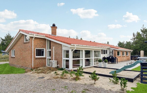 A two-story brick house with a red-tiled roof, large windows, and a covered patio area. - Gorgeous home in Blåvand with sauna (Blåvand)