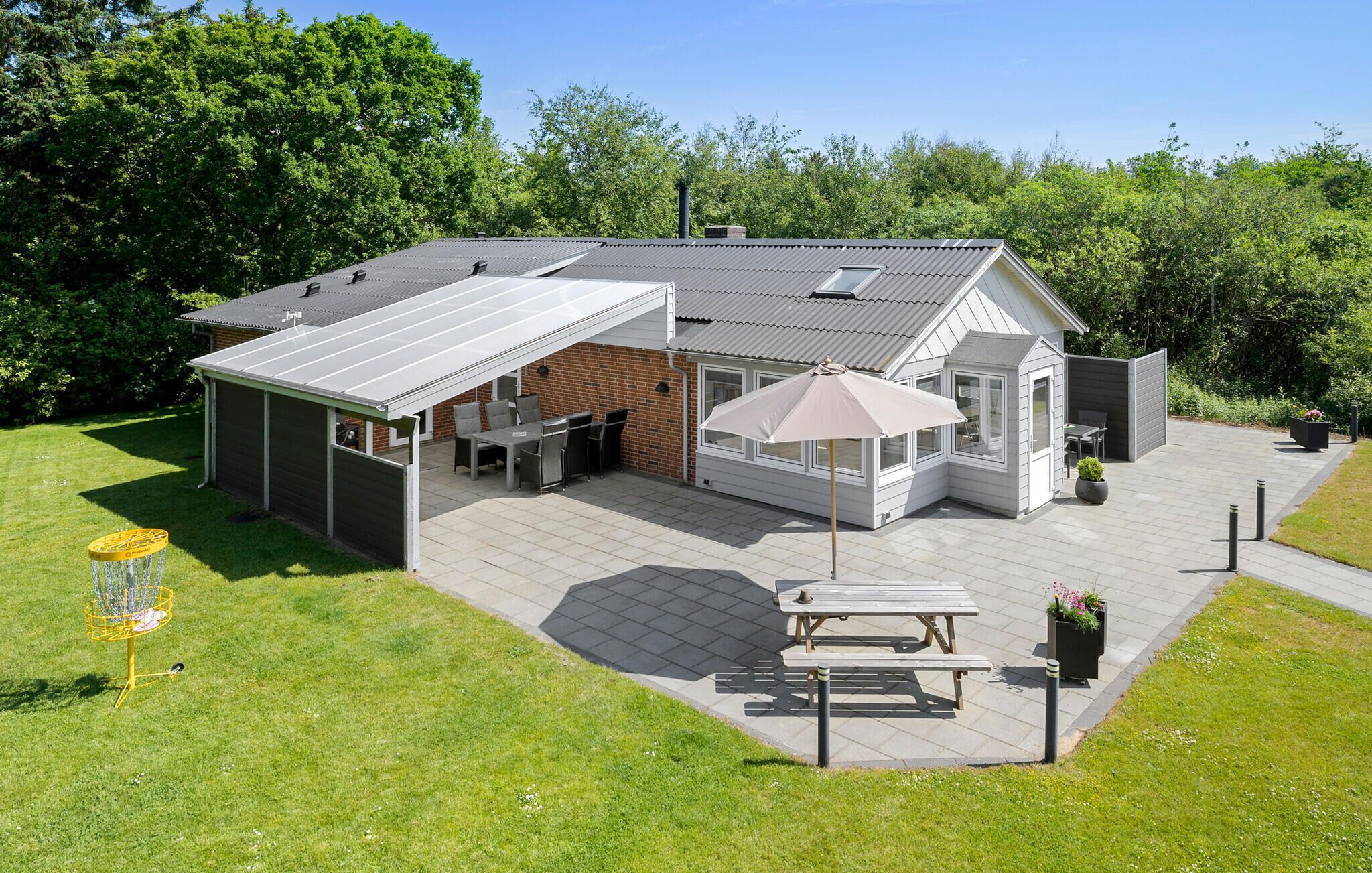 A house with a covered patio, a barbecue area, and a garden.
