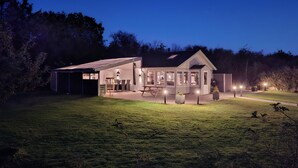 A modern house with a covered patio, a dining area, and a kitchen visible through large windows. - Lovely home in Hurup Thy with sauna (Hurup Thy)