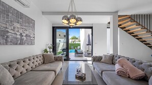 Een moderne woonkamer met twee banken, een salontafel en een trap.
