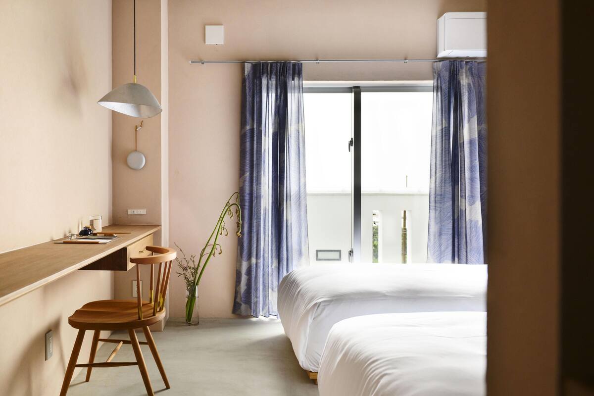 A bedroom with a bed, a desk, and a chair.