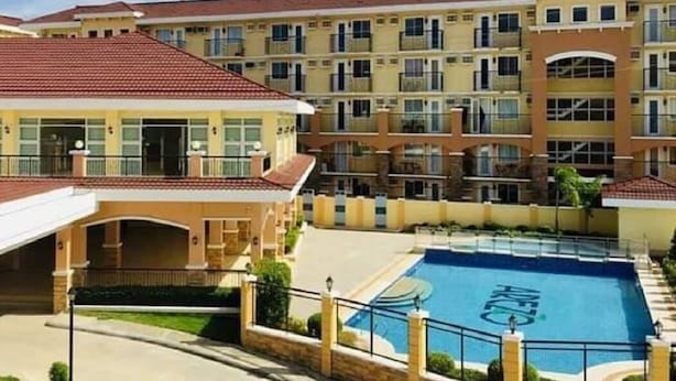 A multi-story hotel with a swimming pool, balconies, and a covered parking area. - Modern minimalist condo in Davao City & very near to Samal Island (Pet Friendly) (Davao City)