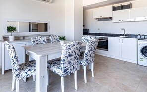 A modern kitchen with white cabinets, a built-in oven, and a washing machine. - Full Seaview beautiful apartment (Red Sea Governorate)