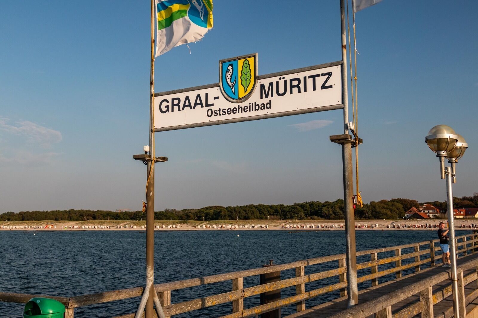 Une jetée sur laquelle on peut lire l’inscription « GRAAL-MÜRITZ Ostseehilbad » et où flotte un drapeau.