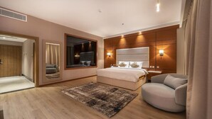Ein modernes Schlafzimmer mit einem großen Bett, einer Sitzecke und einem Spiegel.
